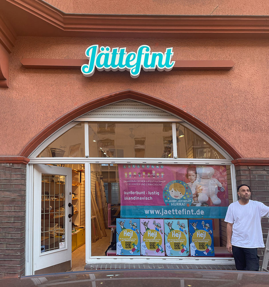 Ladenfront von Jättefint, einem skandinavischen Lifestyle-Shop für Kinder und Erwachsene. Bunte Fensterdekoration und Werbebanner präsentieren das Sortiment. Corporate Design Köln