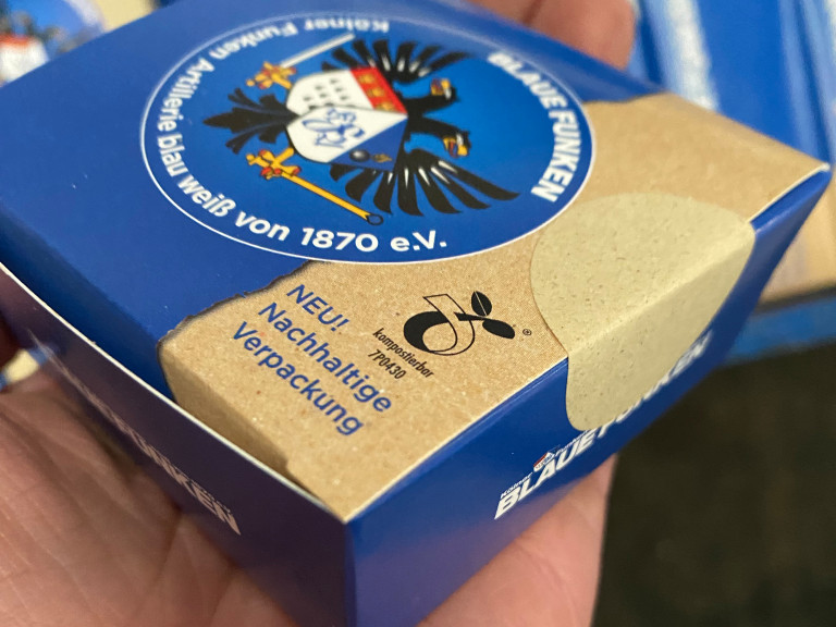 Nachhaltige Verpackung der Blauen Funken, einem Traditionsverein seit 1870. Die Box zeigt das Vereinslogo und hebt die umweltfreundlichen Materialien hervor.
