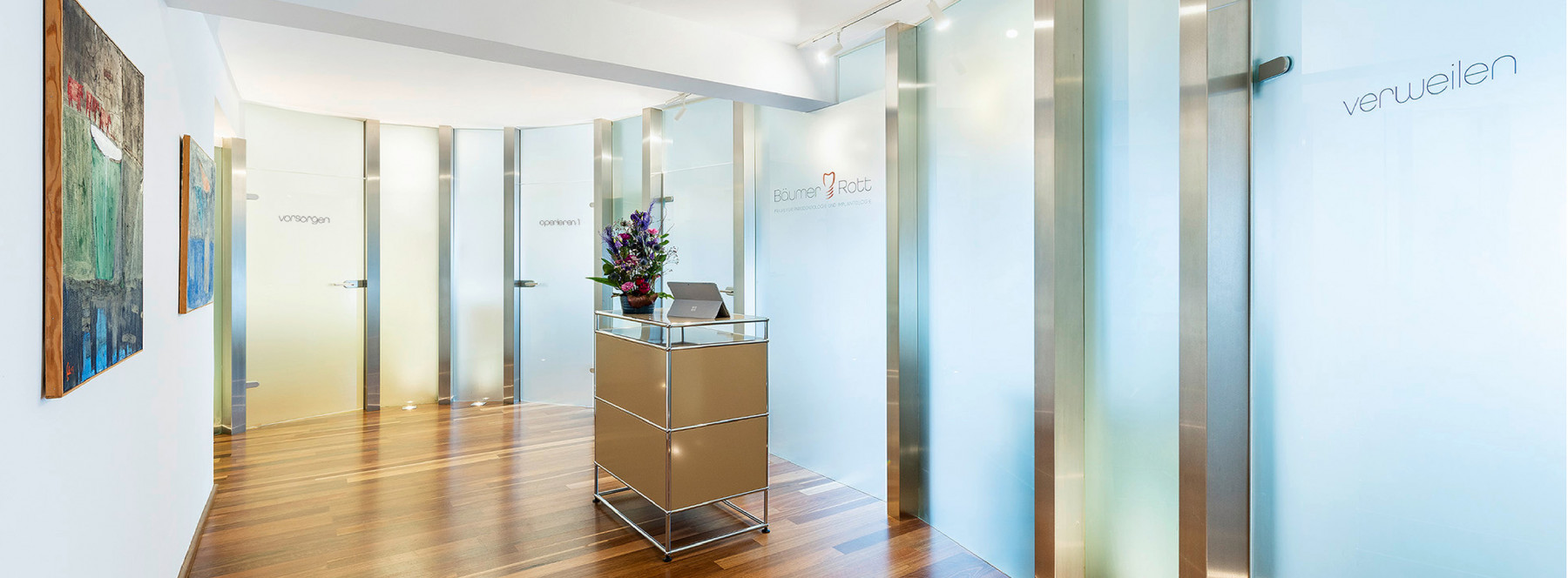 Moderne Empfangshalle mit stilvollen Glastüren und Holzfußboden. Blumenarrangement auf dem Empfangstisch. Kunstwerke an der Wand schaffen eine einladende Atmosphäre.