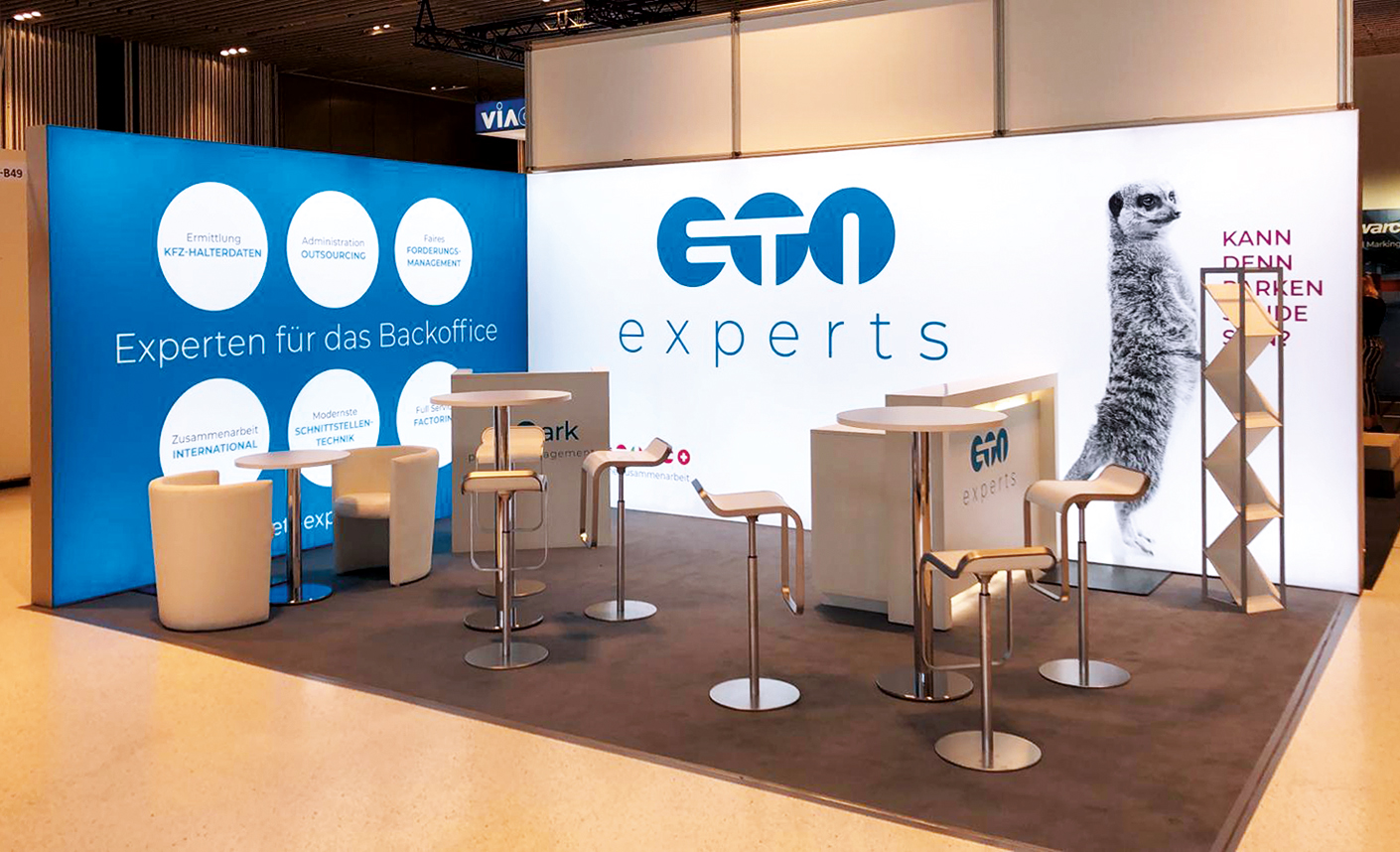 Messestand der ETN Experts, spezialisiert auf Backoffice-Lösungen, mit modernen Möbeln und einem auffälligen Design. Fokus auf Dienstleistungen wie Outsourcing und Datenverwaltung. Corporate Design Köln