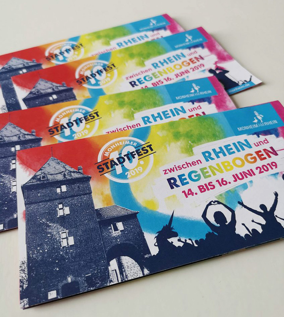 Bunte Werbebroschüren für das Monheimer Stadtfest 2019, das vom 14. bis 16. Juni unter dem Motto "zwischen Rhein und Regenbogen" stattfindet.