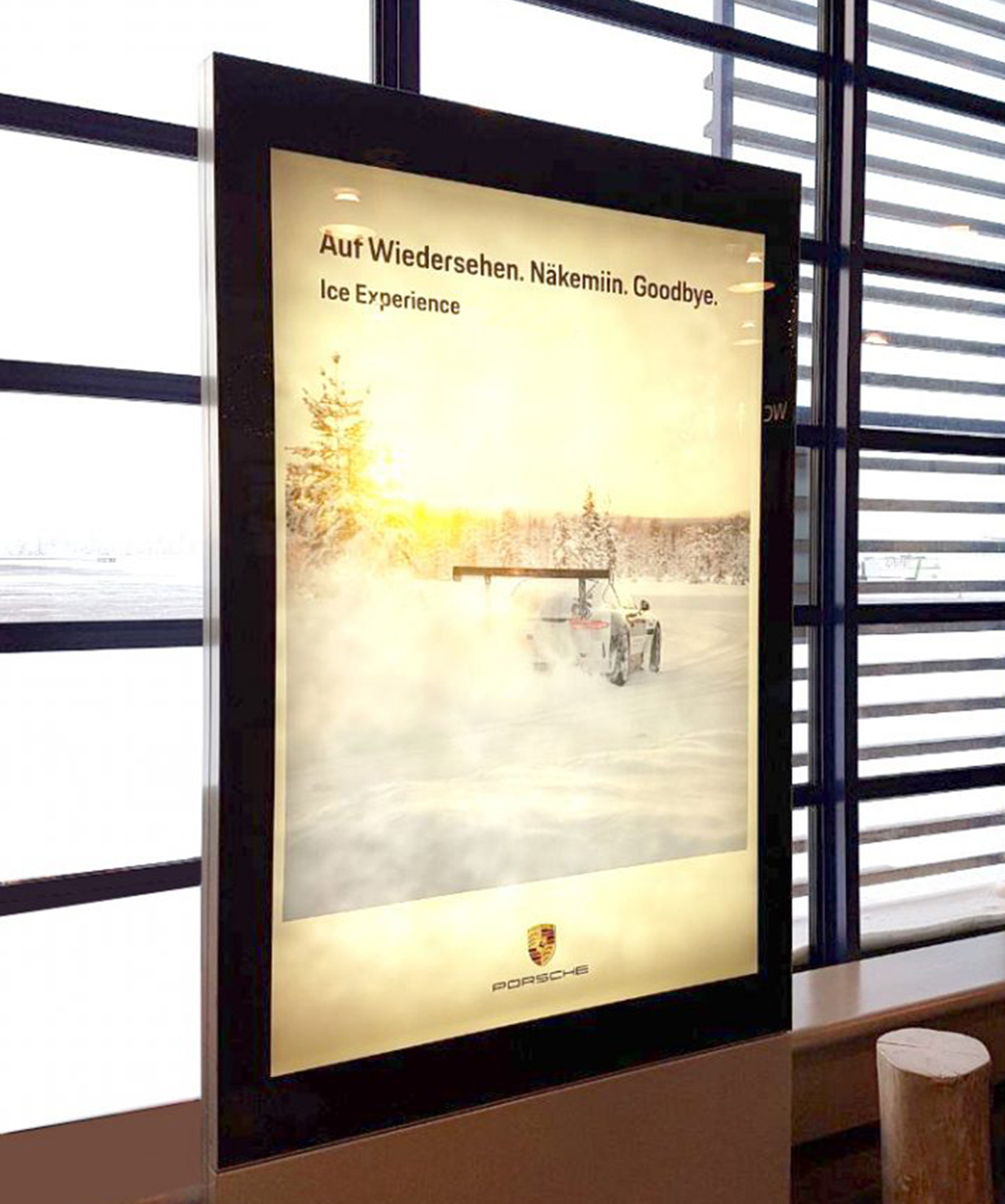 Werbung für das Porsche Ice Experience, mit dem Slogan Auf Wiedersehen in einer winterlichen Landschaft, die ein Auto im Schnee zeigt. Ideal für Motorsport- und Abenteuerliebhaber.