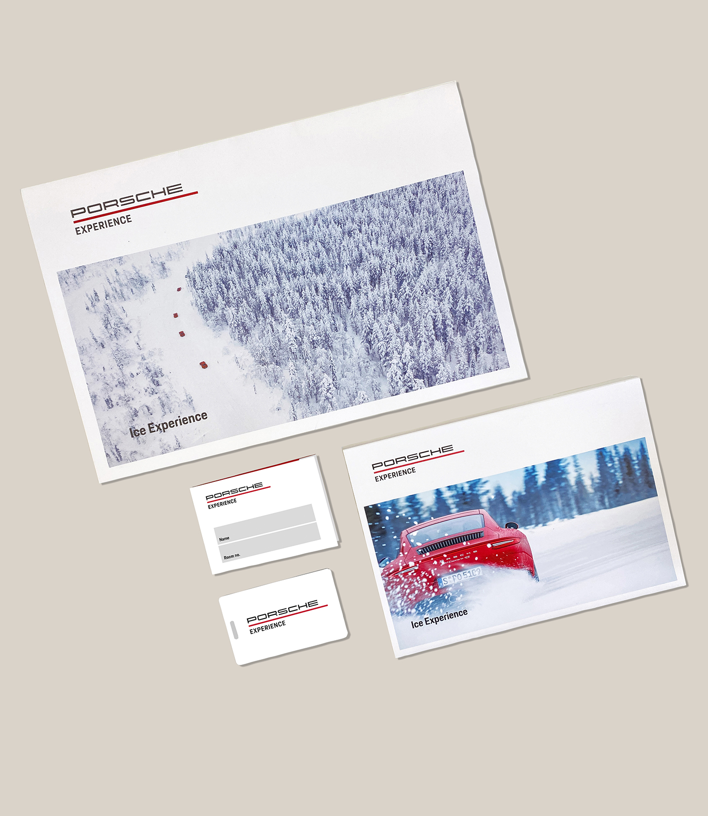 Porsche Ice Experience Materialien, darunter ein Umschlag mit winterlicher Landschaft und rotem Sportwagen, präsentieren ein exklusives Fahrerlebnis im Schnee.