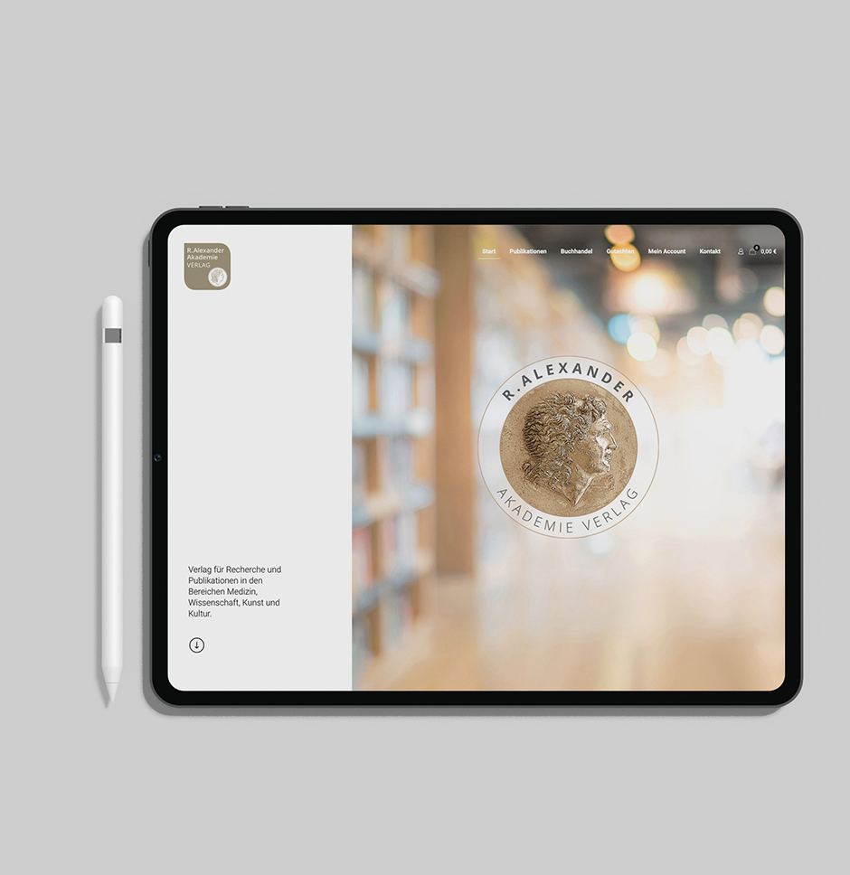 Tablet mit der Webseite des R. Alexander Akademie Verlags, spezialisiert auf Forschung und Publikationen in Medien, Wissenschaft, Kunst und Kultur. Im Hintergrund sind Bücherregale zu sehen. Corporate Design Köln