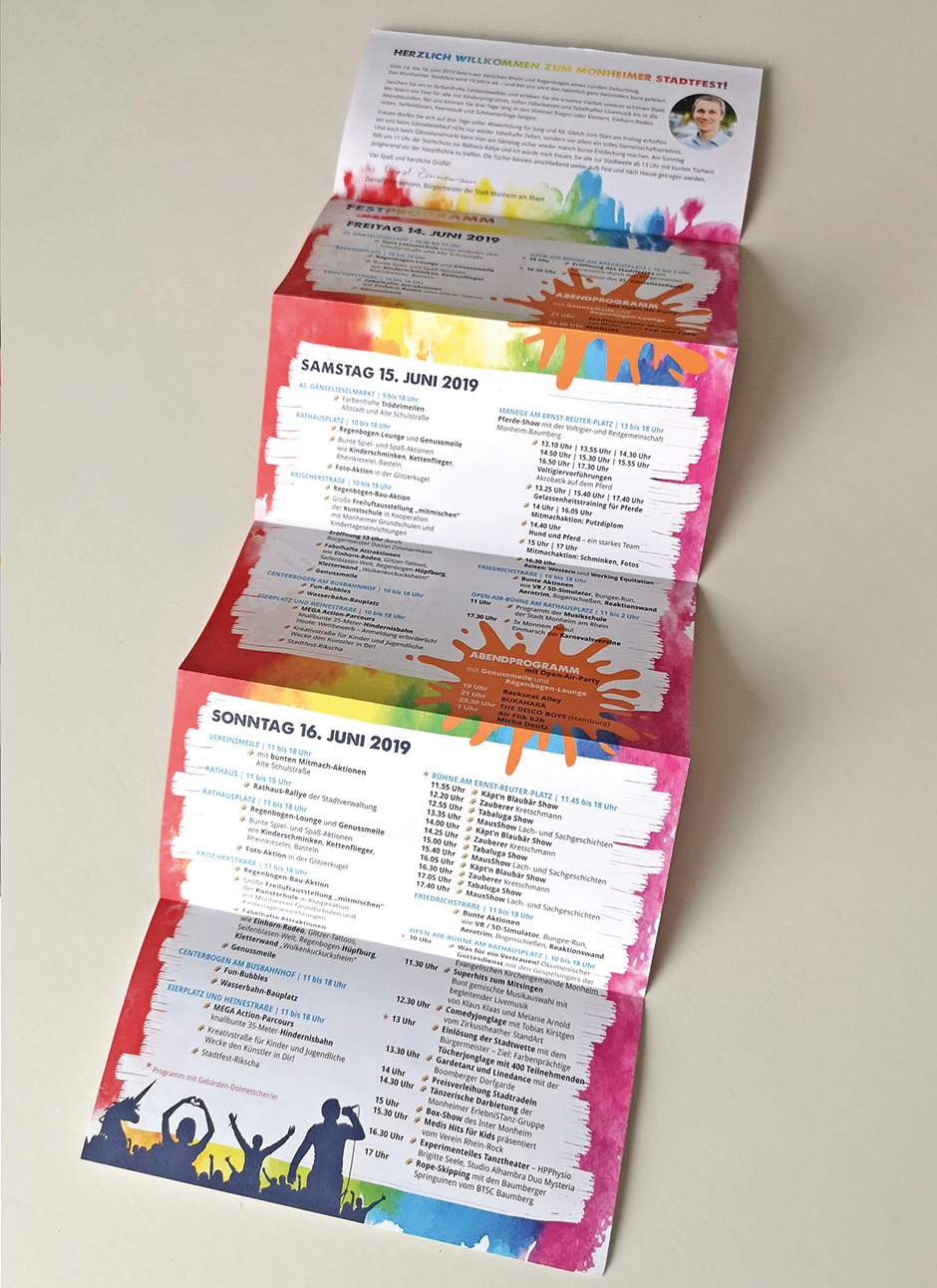 Bunt gefaltetes Programmheft für das Monheimer Stadtfest mit Veranstaltungsdetails für den 14. bis 16. Juni 2019, inklusive Bühnenprogramm und Aktionen.
