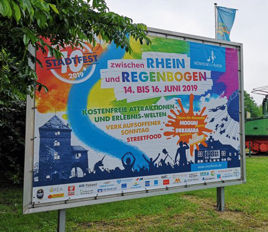 Plakat zum Stadtfest 2019 in Mönchengladbach, das vom 14. bis 16. Juni stattfindet. Es zeigt Angebote wie kostenlose Attraktionen, Open-Air-Konzerte und Streetfood.