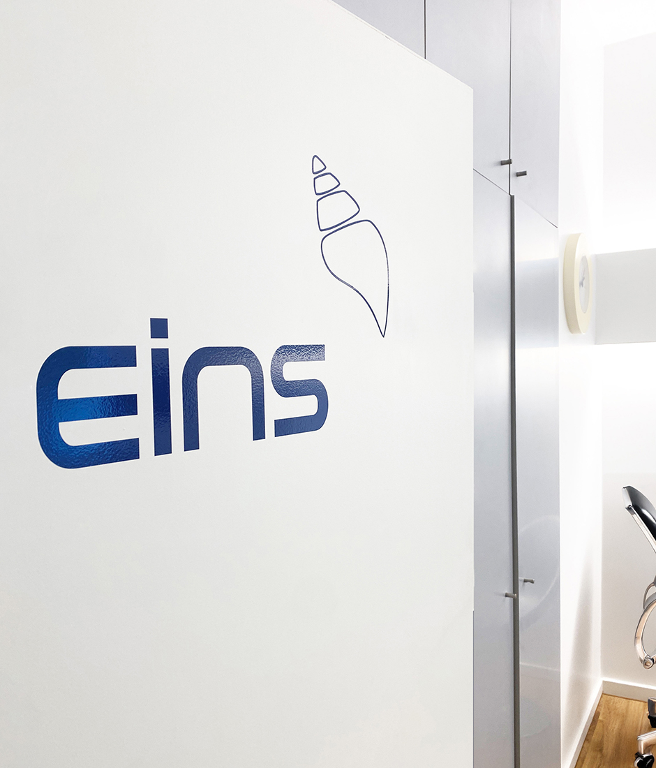 Moderne Innenansicht mit dem Schriftzug eins und einem Muschel-Logo. Ideal für eine ansprechende Praxis- oder Büroumgebung, die Professionalität und Kreativität vermittelt. Webdesign für Arztpraxen Köln